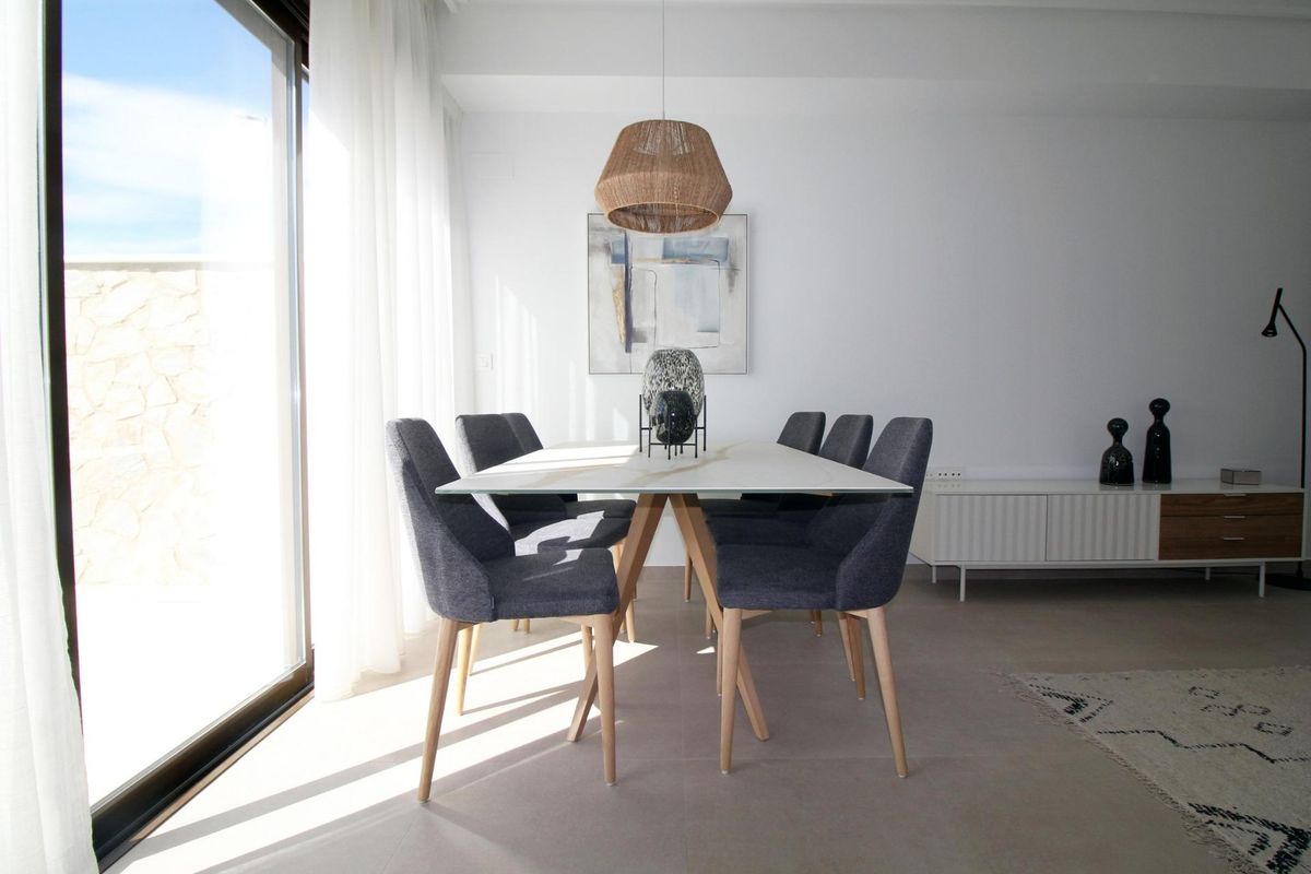 Stijlvolle eetruimte met een tafel en stoelen bij grote ramen in de tussenwoning, Pilar de La Horadada.