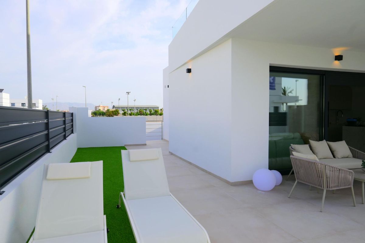 Zonovergoten terras met ligstoelen en zwembad, ideaal voor ontspanning in een townhouse in Dolores, Costa Blanca Zuid.