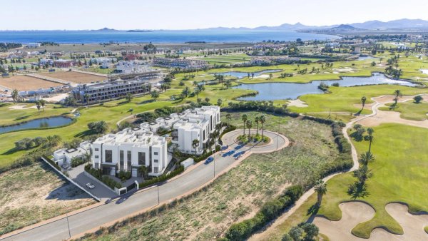 Aerial view of a modern 3-bed apartment complex in Los Alcazares, surrounded by a scenic golf course.