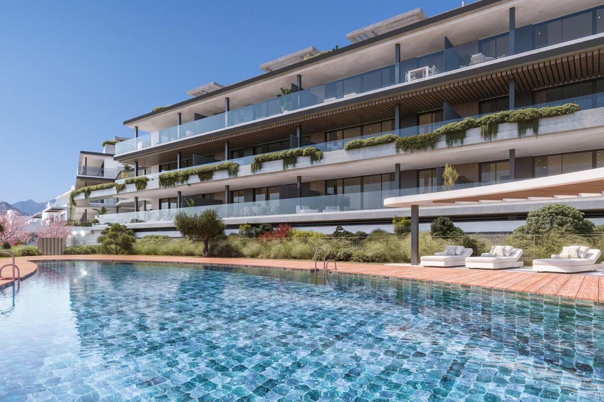 Moderne buitenkant van een penthouse met een zwembad in Estepona, met weelderig landschap.