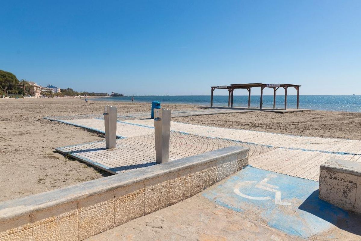 Zamelijk uitzicht op het strand in San Javier met een houten loopplank en strandpaviljoen aan zee, perfect voor uitjes.