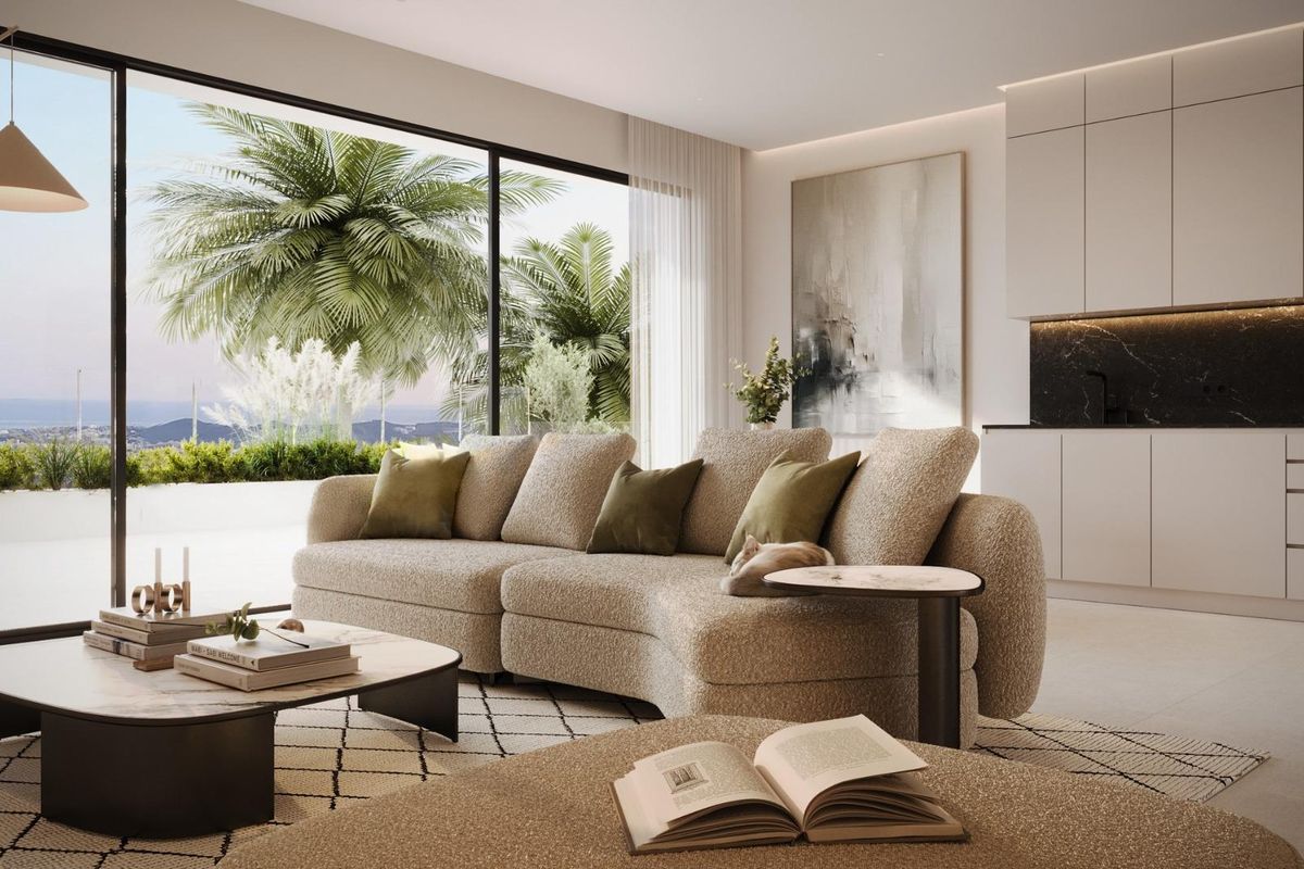 Ruime woonkamer met een grote bank en uitzicht op palmbomen en de oceaan vanuit het penthouse in Mijas.