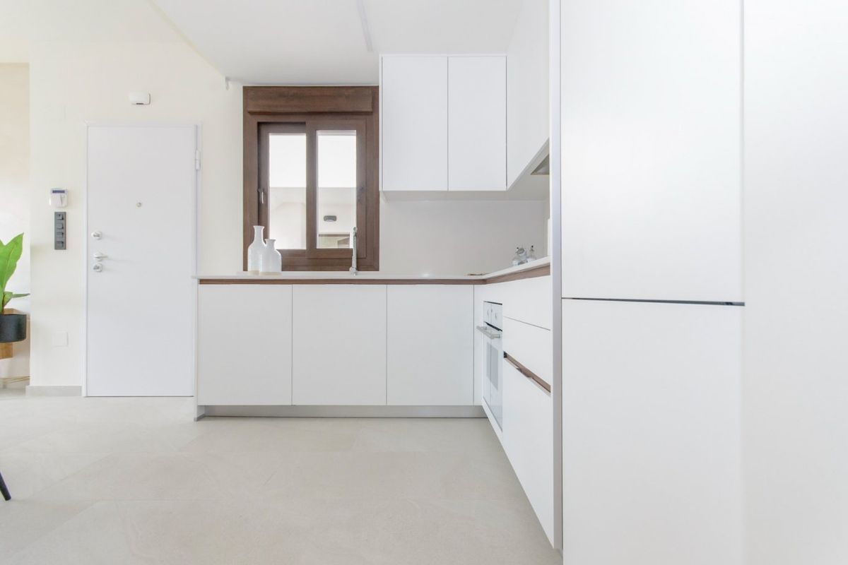 Functionele keukenindeling met moderne inrichtingen en witte kasten in deze bungalow in Torrevieja.