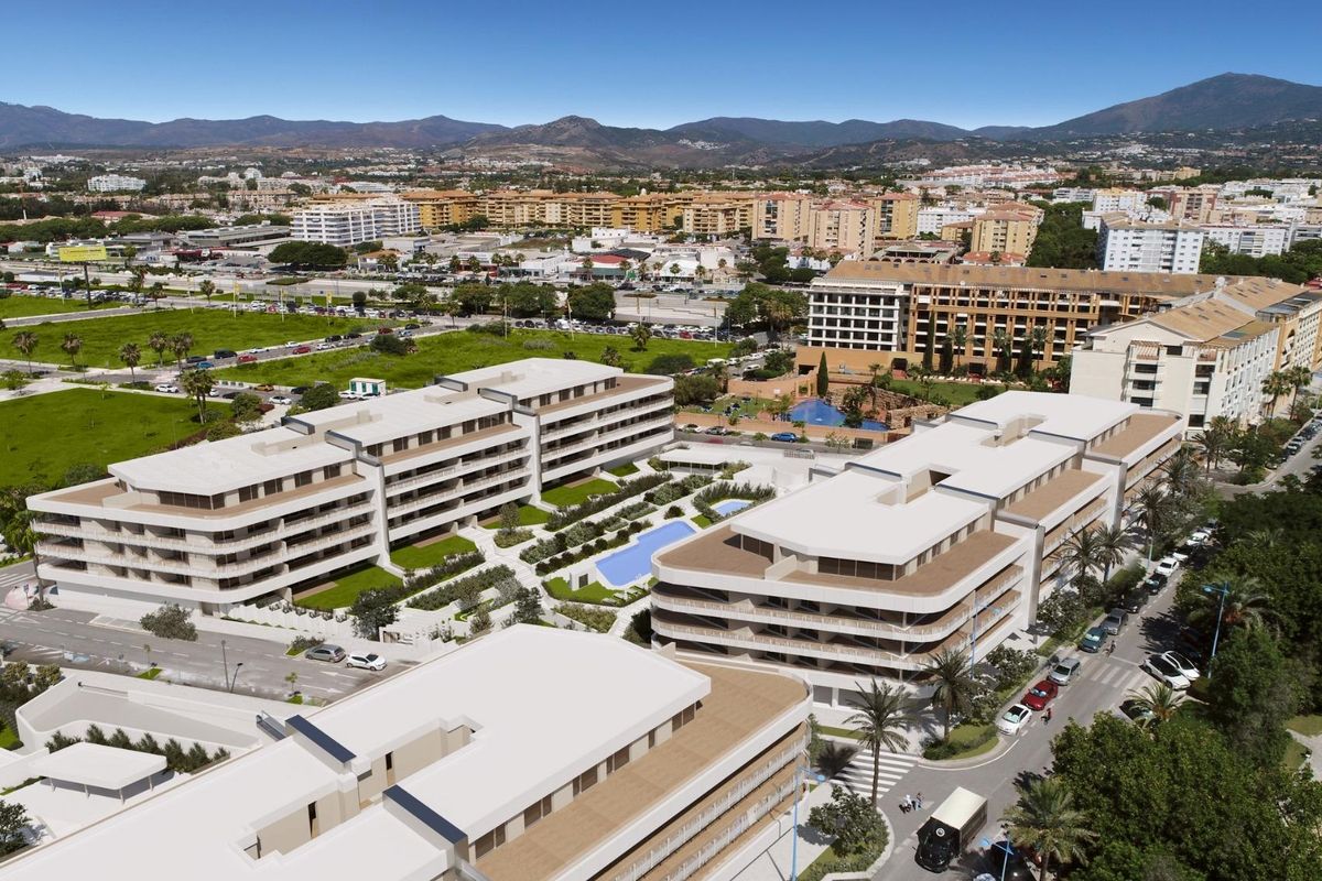 Adembenemende luchtfoto van een appartementencomplex en omliggende groene gebieden in Marbella, Costa del Sol.