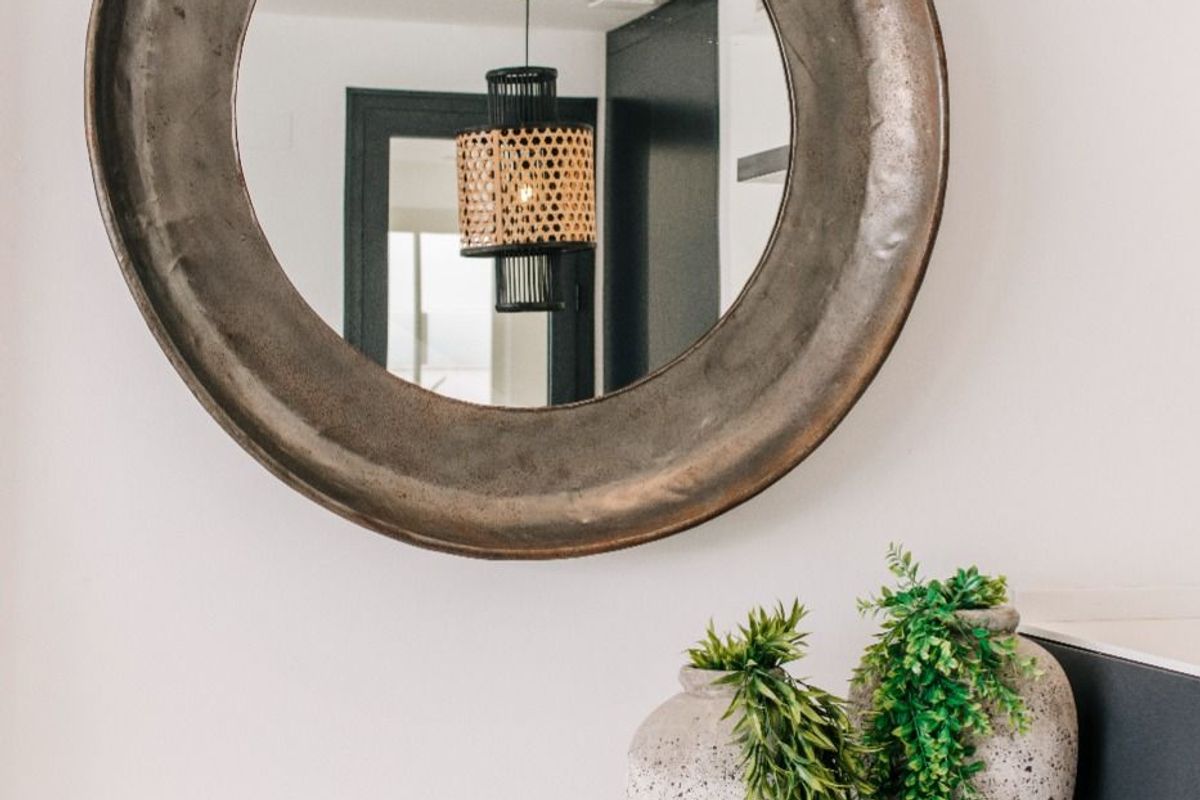 Close-up van decoratieve items en een ronde spiegel in de gezellige sfeer van het appartement in Rojales.