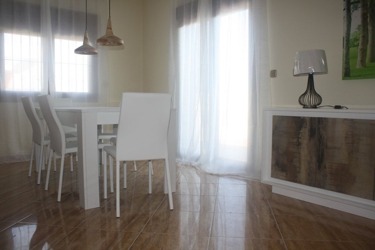Eetruimte in de villa met een witte tafel en stoelen, verlicht door natuurlijk licht in Torrevieja.