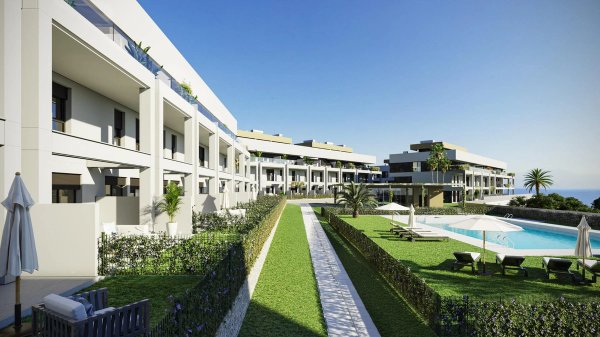 Buitenaanzicht van een modern appartementencomplex met een zwembad en weelderig groen in Estepona, Costa del Sol.