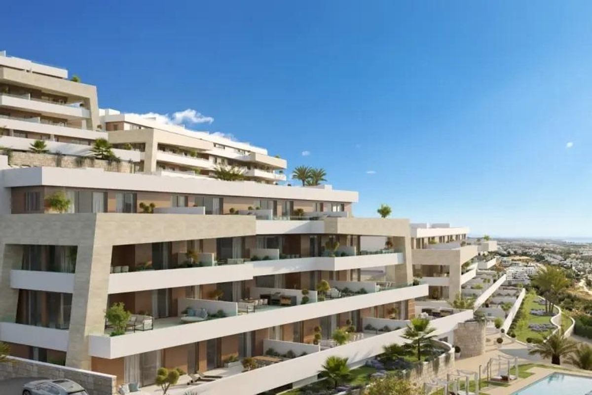 Moderne buitenkant van een 5-slaapkamer appartement in Estepona, Costa del Sol, omringd door palmbomen.