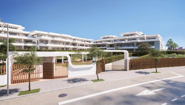 Moderne buitenaanzicht van een 2-slaapkamer appartement complex in Estepona, met strakke architectuur en tuinen.
