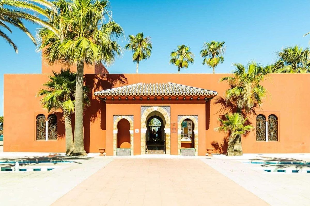 Cultureel centrum met een levendige façade in Benalmádena, omringd door palmbomen en open ruimte.