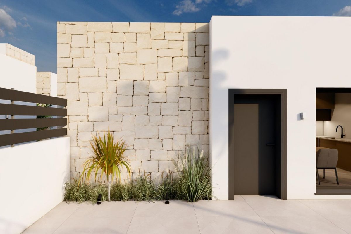 Zijaanzicht van een hedendaagse villa in Benijofar, met natuursteen en landschapstuin.
