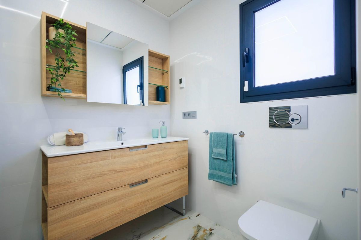 Moderne badkamer met houten accenten en natuurlijk licht in de villa in Pilar de La Horadada.