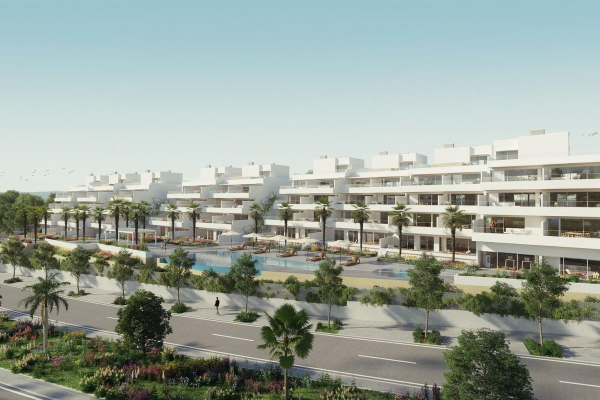 Voorkant van een stijlvol appartementencomplex in Estepona met aangelegde tuinen en palmbomen.