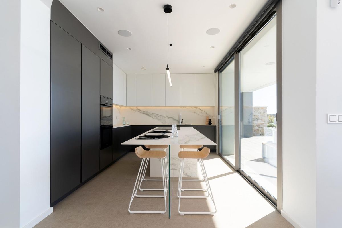 Sleek modern kitchen in the villa with breakfast bar and large windows bringing in natural light.