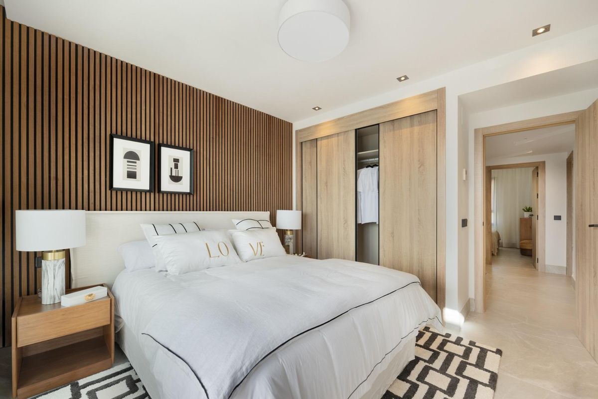 Gezellige slaapkamer met warme houten accenten en moderne inrichting in het 3-slaapkamer herenhuis in Istán, Costa del Sol.