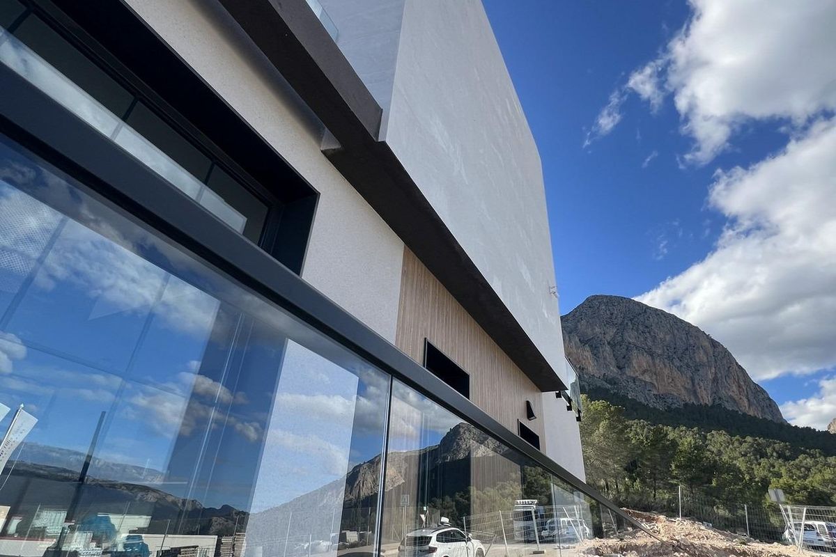 Zij-aanzicht van een hedendaagse townhouse in Polop, Costa Blanca Noord, dat het strakke ontwerp en de omgeving vastlegt.