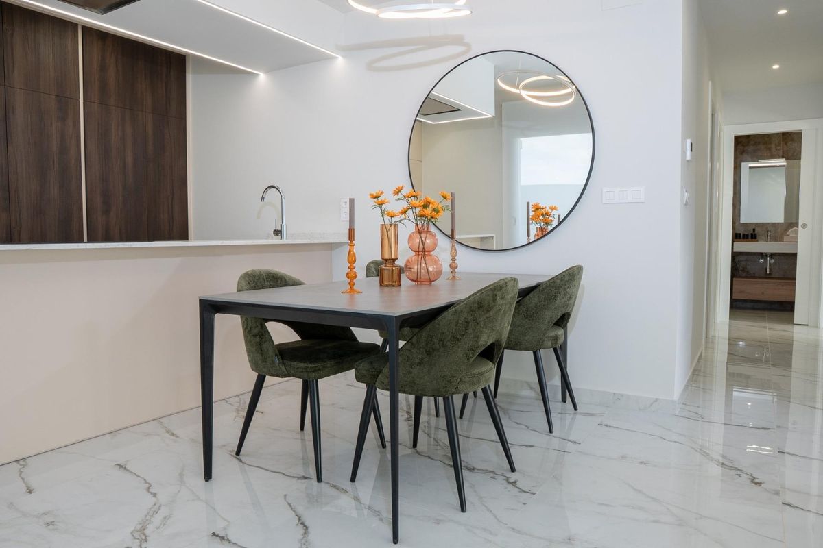 Elegante eetkamer met een ronde spiegel en stijlvolle tafel, gelegen in een 3-slaapkamer villa in Ciudad Quesada.