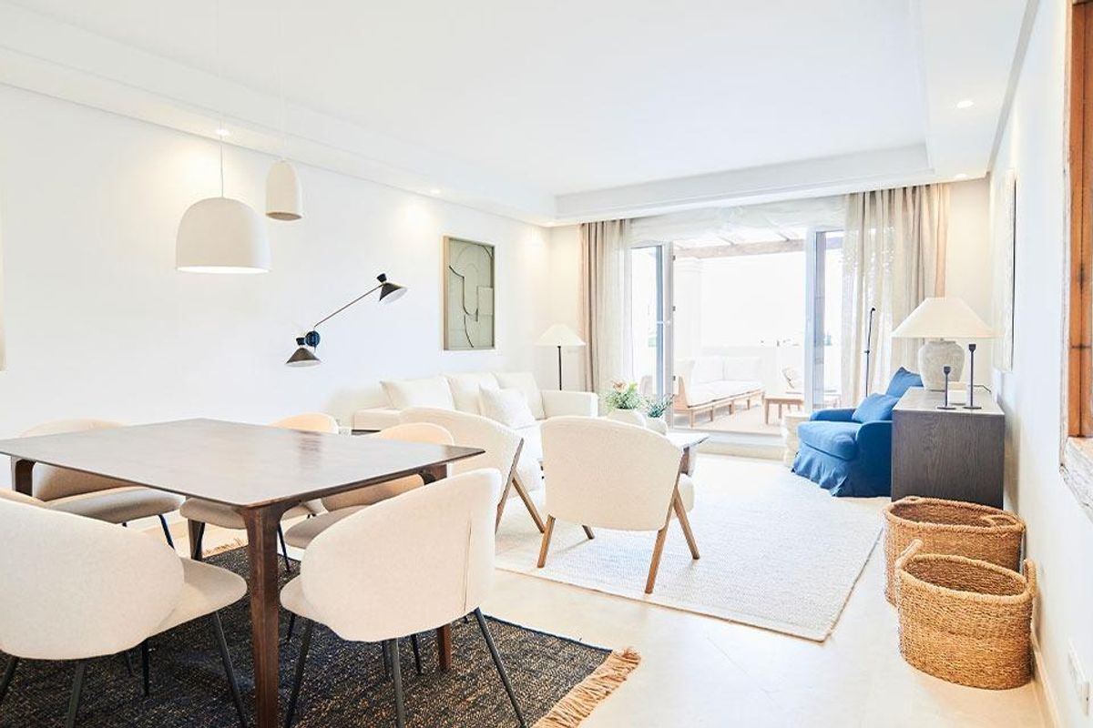 Elegante eetruimte met een grote tafel en open indeling die naar het terras leidt in Marbella.