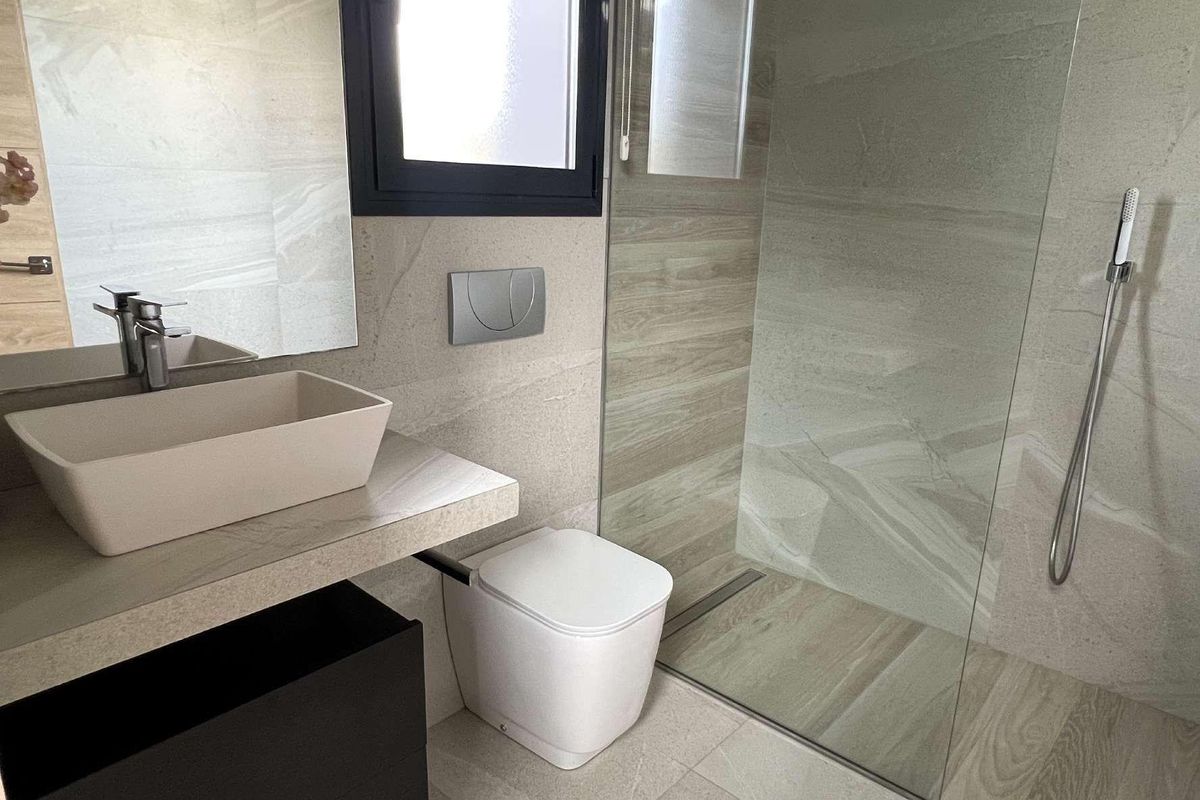 Moderne badkamer van een 3-slaapkamer villa in Rojales, met stijlvolle armaturen en een glazen douche.