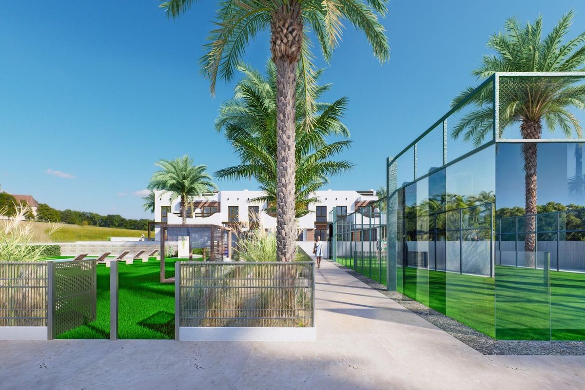 Tuinpaden die naar de bungalow leiden met groen en het zwembad in Pilar de La Horadada.