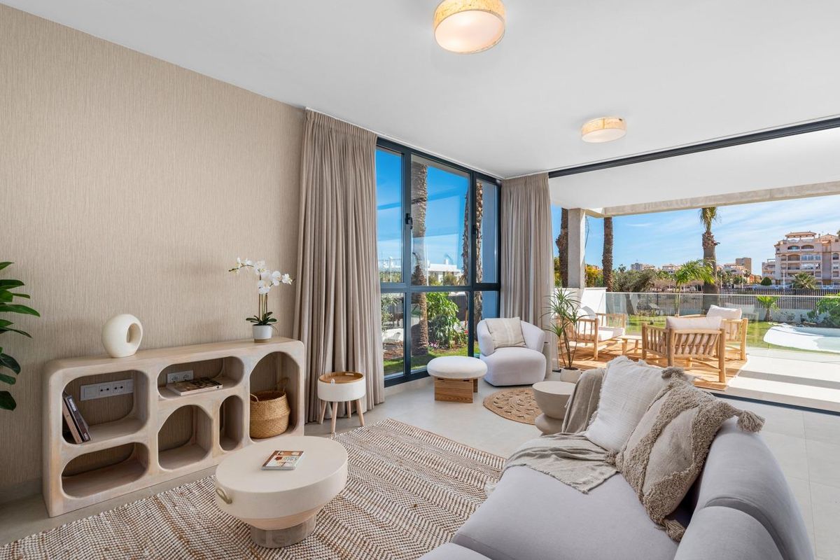 Chique woonkamer met beige decor en uitzicht op de tuin in Cartagena, Spanje.