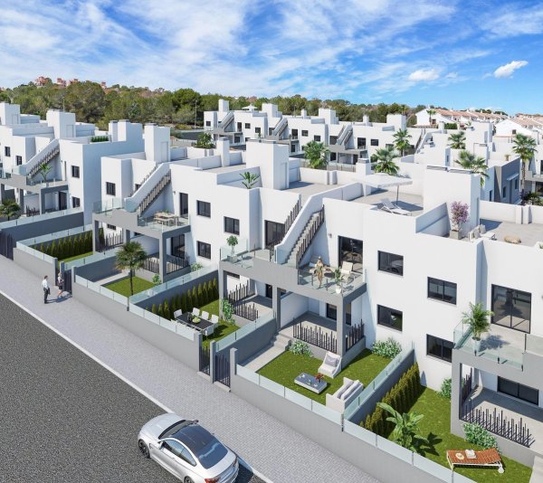 Buitenaanzicht van een modern appartementencomplex in San Miguel de Salinas, met witte gebouwen en tropische planten.