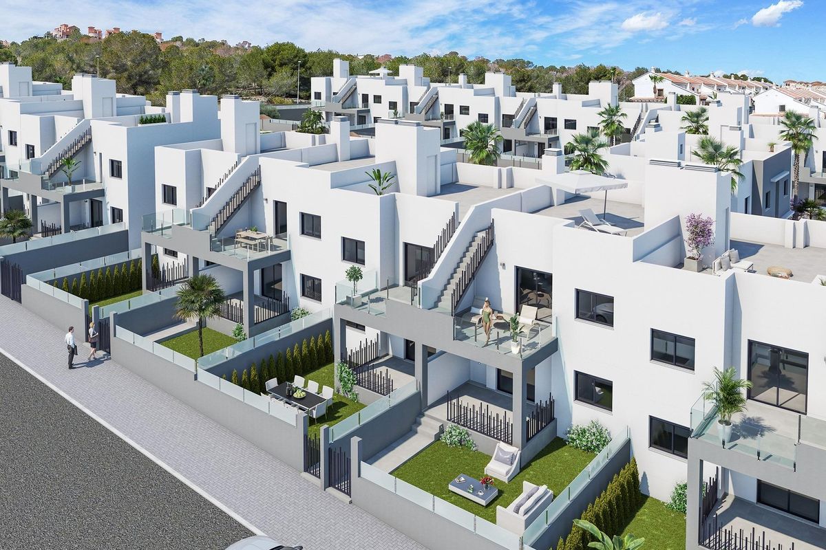 Brede opname van het moderne appartementencomplex in San Miguel de Salinas met buitenruimtes en groene aanplant.