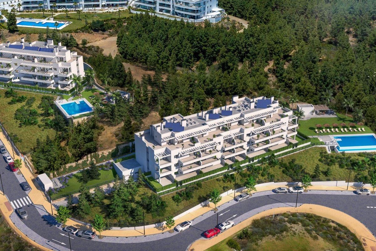 Luchtfoto van een stijlvol appartementencomplex in Mijas, met aangelegde tuinen en zwembaden.
