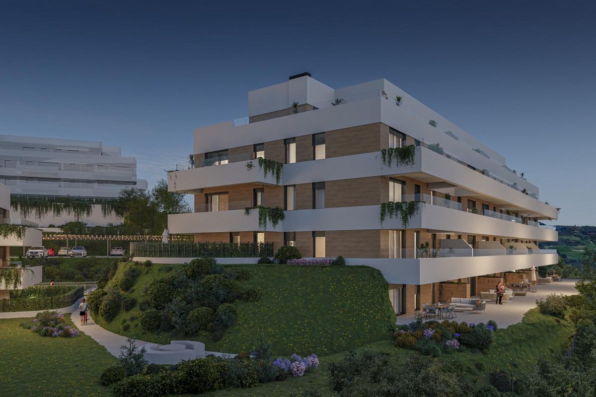 Avondzicht op een stijlvol appartementencomplex met terrassen in Mijas, Costa del Sol.