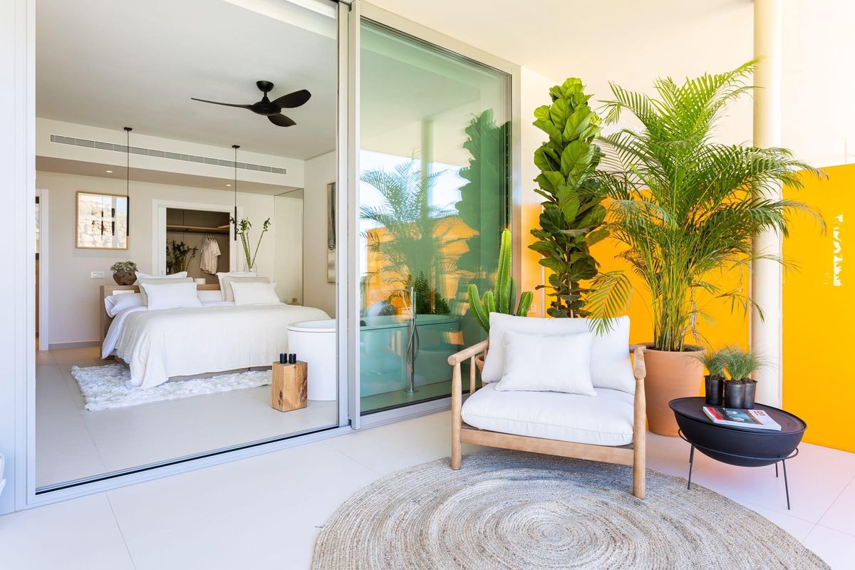 Heldere slaapkamer met moderne inrichting en toegang tot het terras in een appartement op de begane grond in Fuengirola.