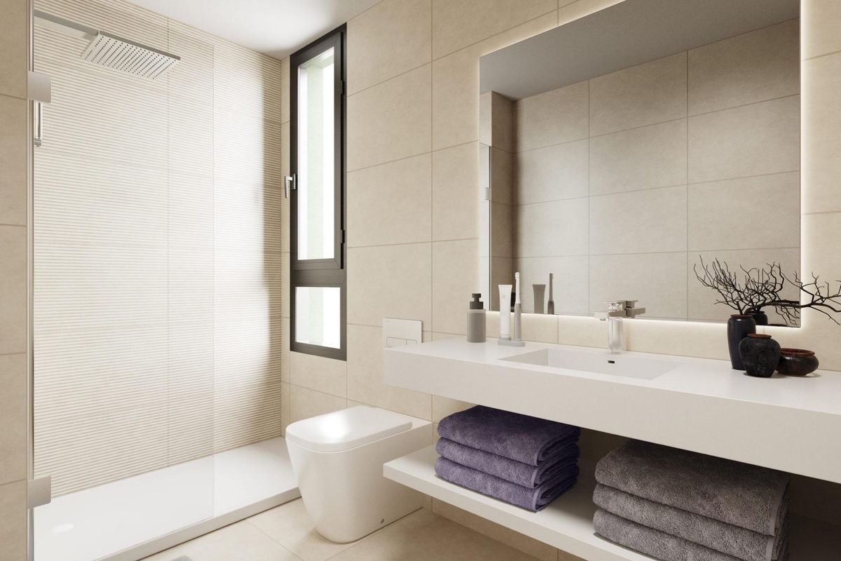 Strak badkamerontwerp in een appartement aan de Costa del Sol, met moderne armaturen en voldoende ruimte.