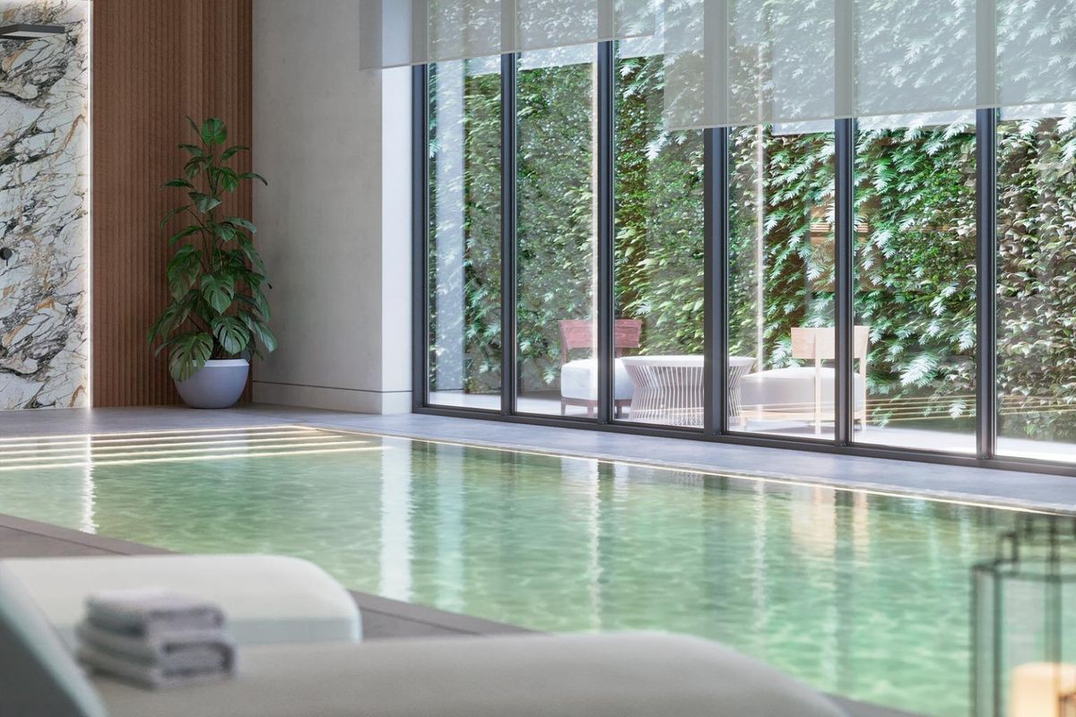 Luxe binnenzwemruimte in een penthouse in Marbella, met grote ramen en stijlvolle zitplaatsen bij het water.