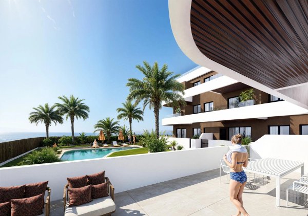 Terras van een appartement op de begane grond met zwembad en palmbomen in Guardamar del Segura, Costa Blanca.