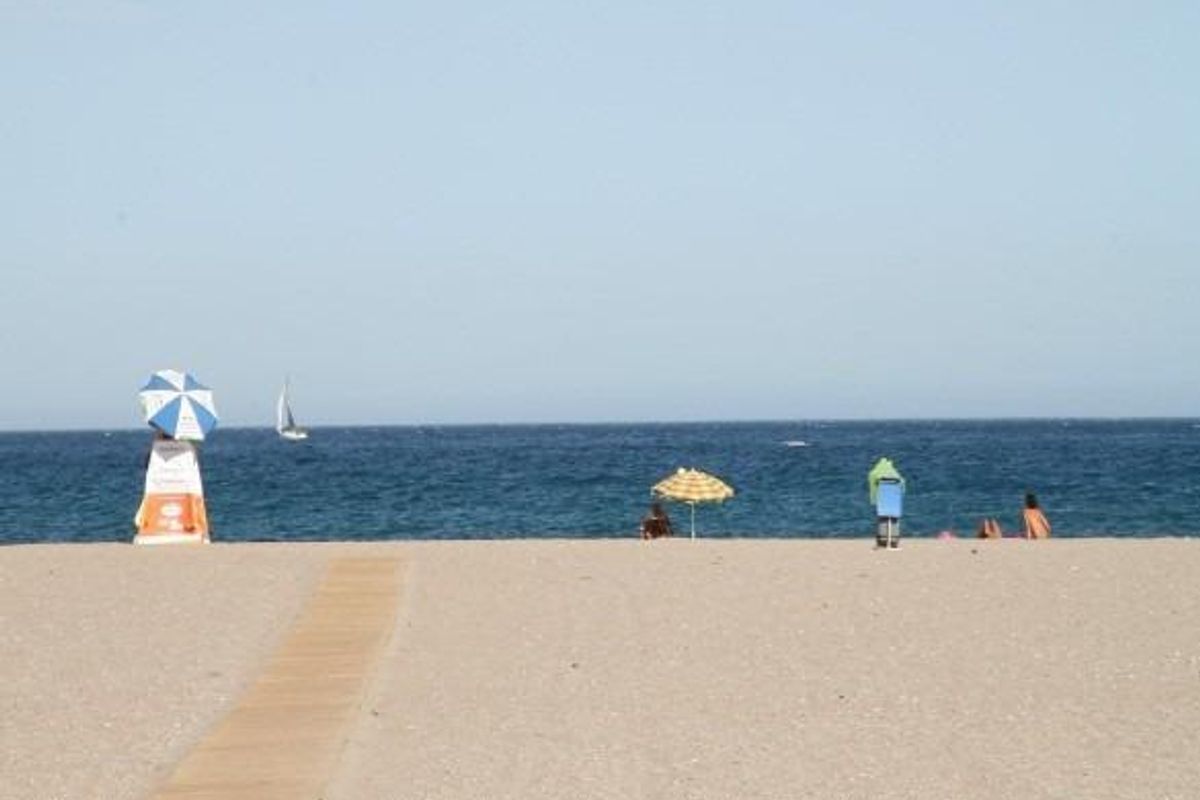 Schilderachtig uitzicht op het strand in Vera, Costa de Almeria, met zonnebaders en parasols aan de kust.