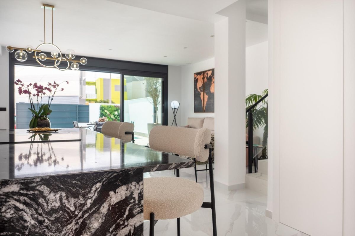 Eigentijdse keuken en eetruimte met stijlvolle barkrukken en uitzicht op de tuin in San Pedro del Pinatar.