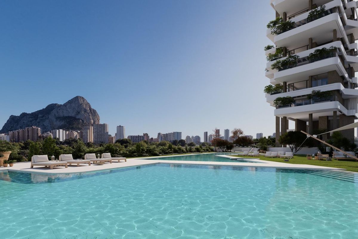 Zicht op het zwembad vanuit het appartement met het iconische Calpe-rots en de skyline.