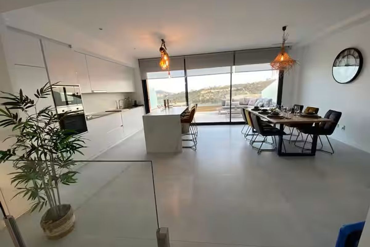 Ruime eet- en keukenruimte met grote ramen in een duplex in Finestrat, met uitzicht op de kust.