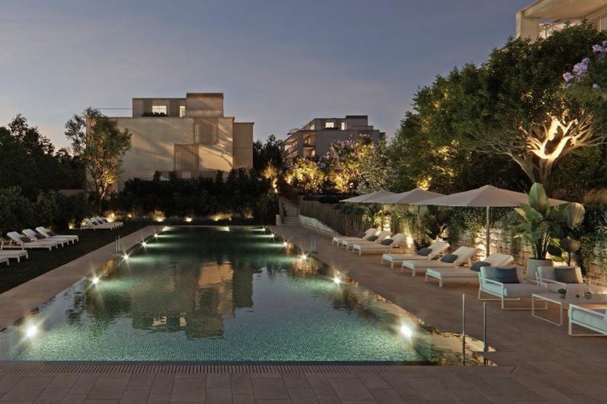 Avondzicht op het gemeenschappelijke zwembad in Godella, verlicht met sfeerverlichting voor een serene sfeer.