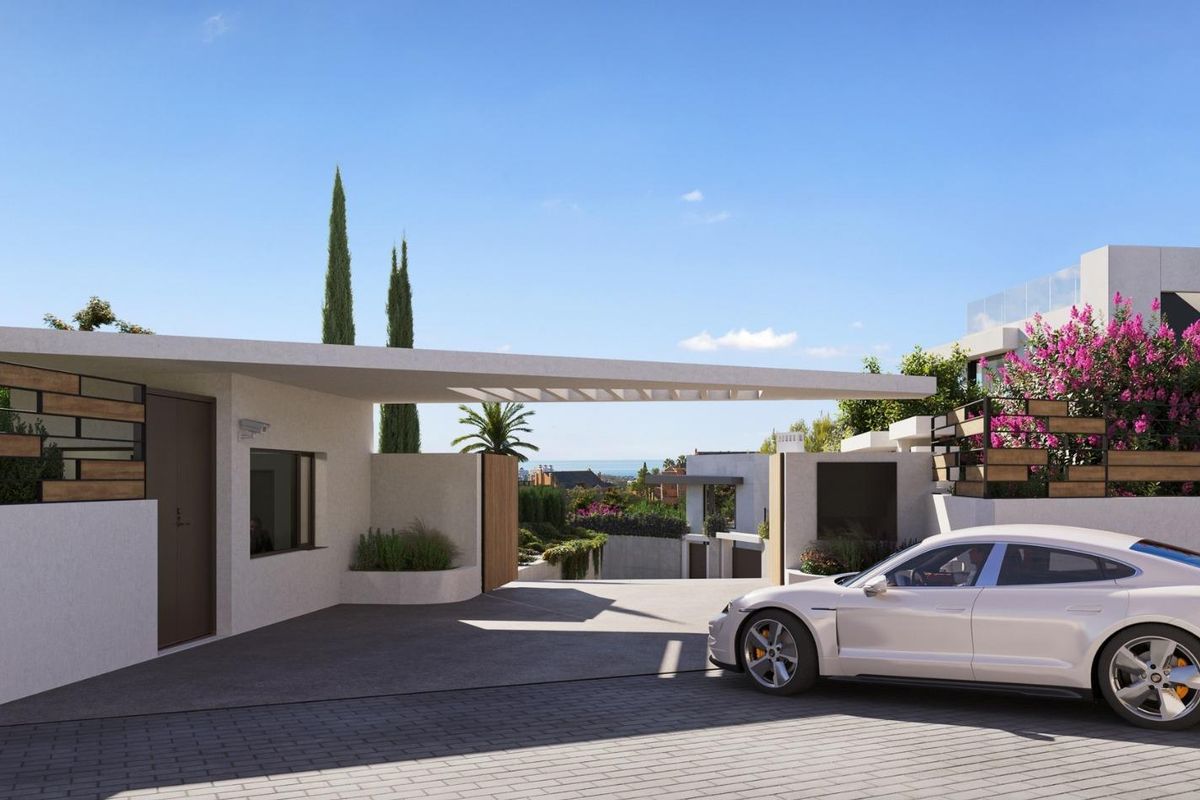 Elegante ingang naar een villa met een luxe auto geparkeerd in weelderige tuinen in Marbella, Costa del Sol.
