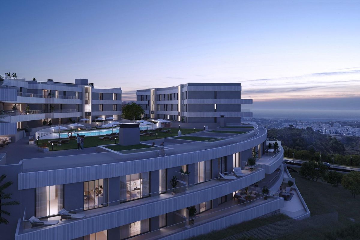 Avondzicht op een hedendaags 2-slaapkamer appartementcomplex in Estepona, met buitenverlichting en sfeer.