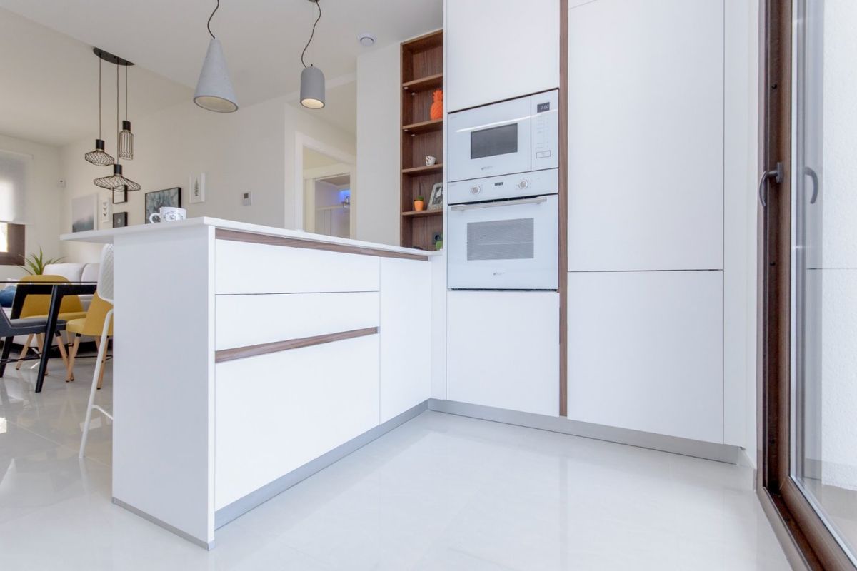 Strakke keukenhoek met moderne apparatuur en minimalistisch design in het gelijkvloerse appartement in Torrevieja.