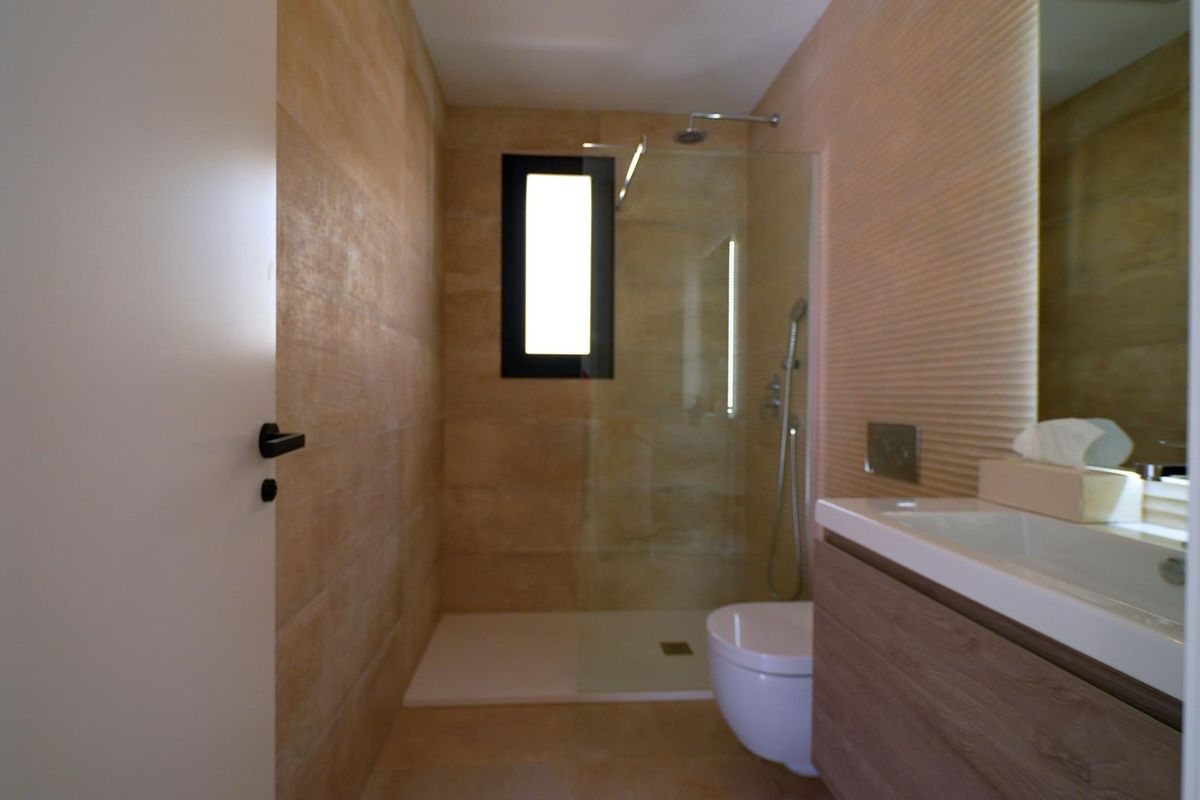 Moderne badkamer met strakke lijnen en natuurstenen in de 3-slaapkamer villa in Orihuela Costa.