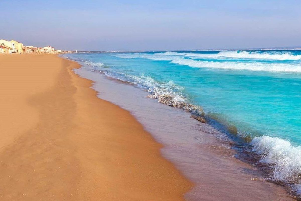 Rustig strandbeeld langs de kust nabij San Fulgencio, met zachte golven en helder water.