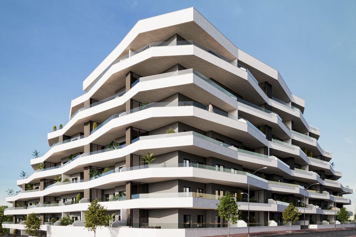 Hoekzicht van het moderne appartementencomplex in San Miguel de Salinas, met meerdere balkons.