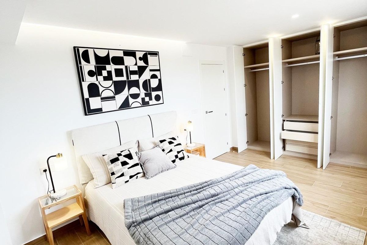Helder verlichte slaapkamer met een tweepersoonsbed en georganiseerde kast ruimte in een villa in Algorfa, Spanje.
