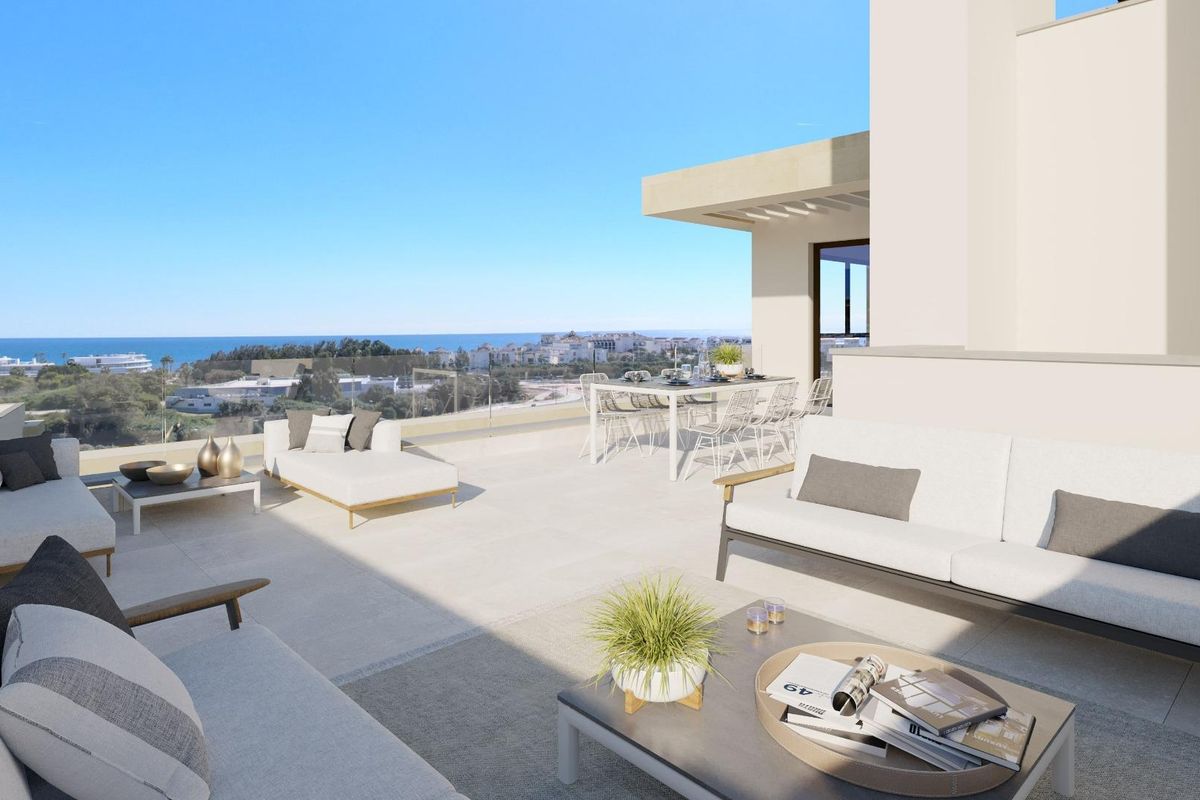 Ruime terras van een 3-slaapkamer penthouse in Estepona met uitzicht op de oceaan, stijlvolle meubels en heldere sfeer.