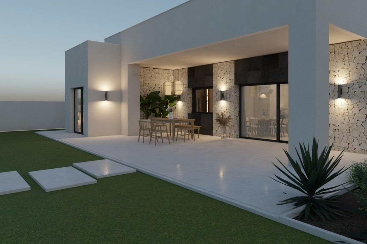 Exterior view of a contemporary 3-bed villa in Pinoso, featuring a spacious terrace and green lawn.