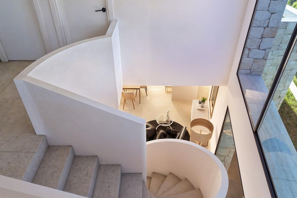 Overzicht van de spiraaltrap in de villa in Moraira, goed verlicht en modern.