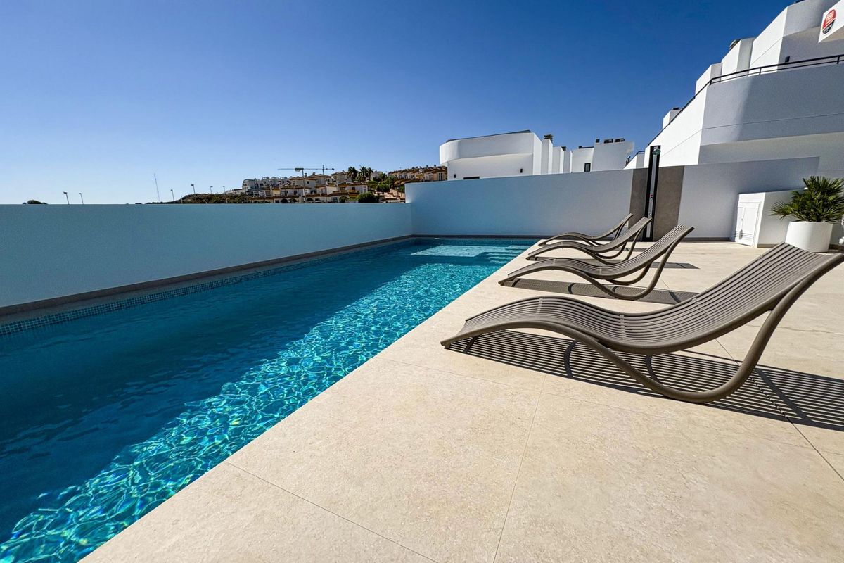 Verfrissend zwembadzicht met ligstoelen bij een moderne villa met 5 slaapkamers in Rojales, gelegen in een rustige omgeving.