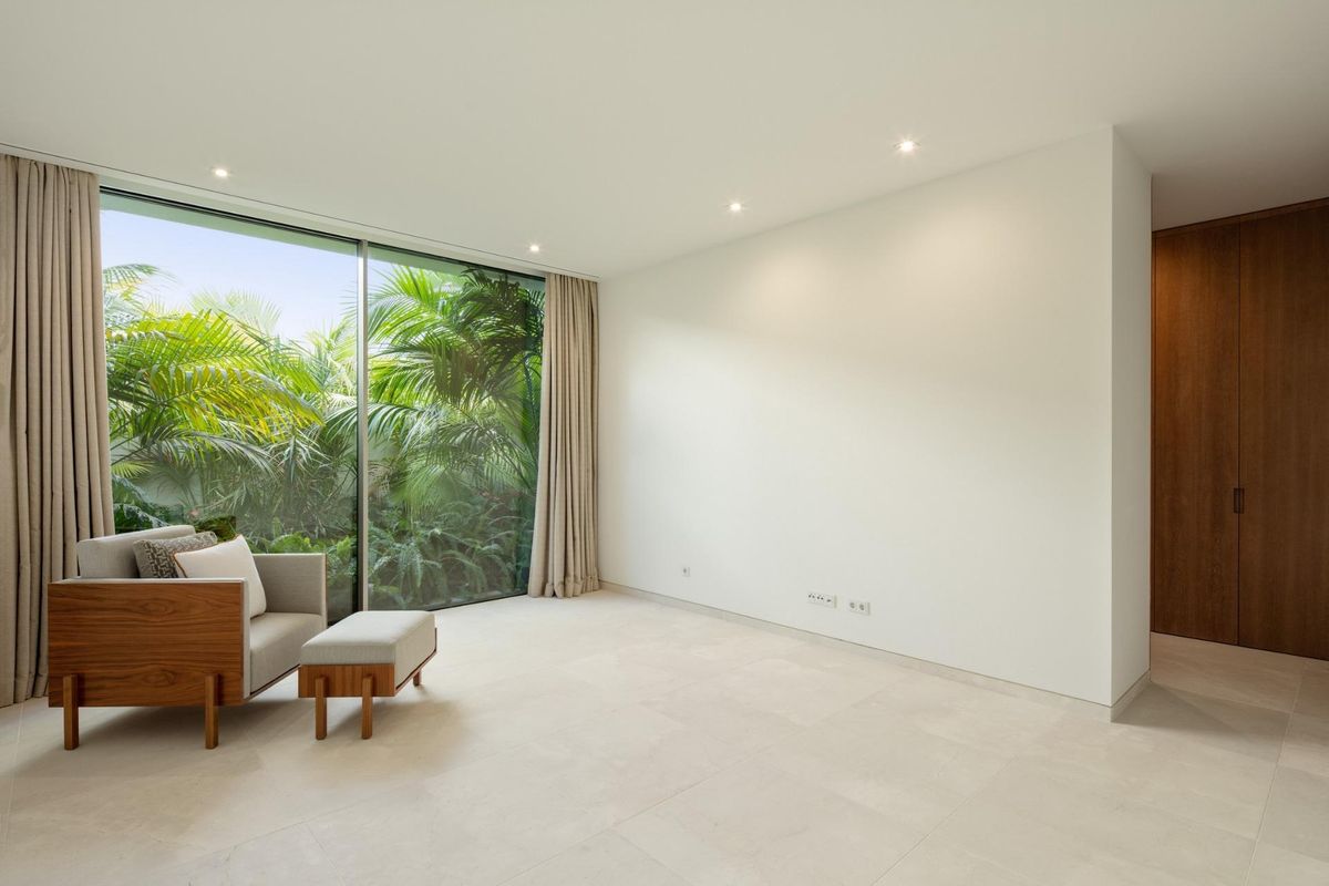 Minimalistische slaapkamer in de villa in Casares met grote glasdeuren naar prachtige groene omgeving.